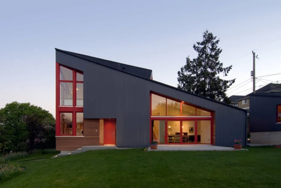 серый дом с красными окнами и односкатной крышей