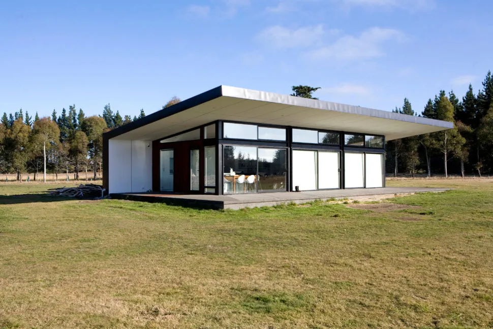 современный дом со стеклянными стенами и односкатной крышей